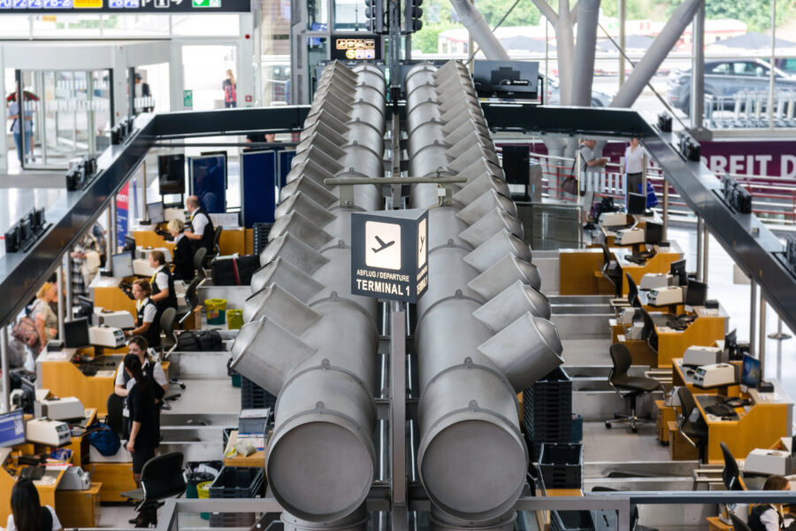Blick auf Check-in-Schalter im Flughafen, Schild "Abflug Terminal 1".