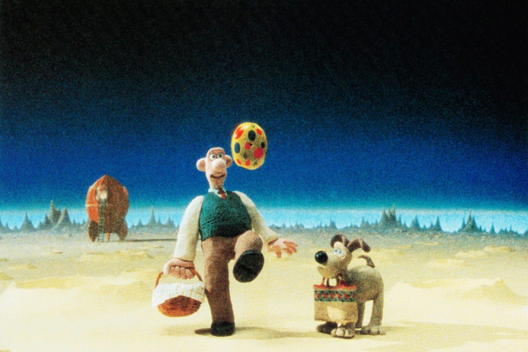 Zwei animierte Figuren auf Mondoberfläche, eine Rakete im Hintergrund.