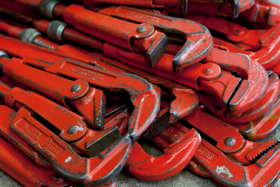 Ein Stapel roter Rohrzangen liegt aufeinander.
