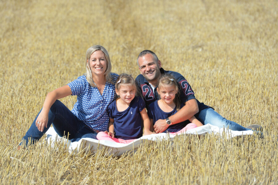 Vier Personen sitzen auf einer Decke im Feld.