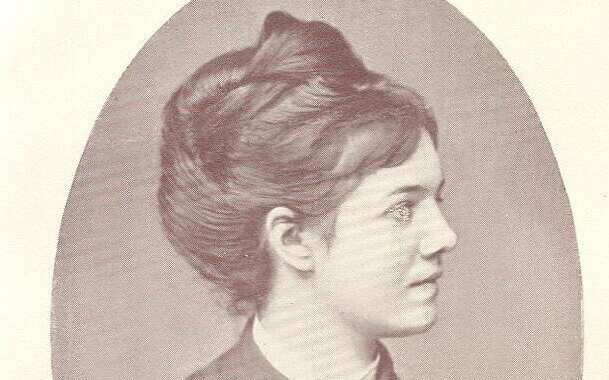 Eine Frau im Profil mit hochgestecktem Haar, in einem ovalen Rahmen.