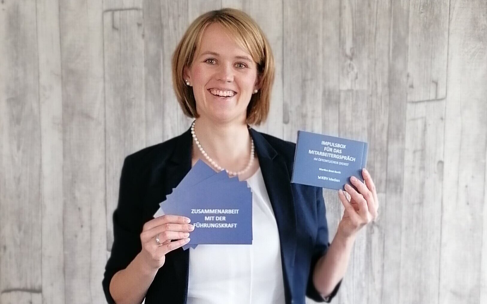 Person mit Karteikarten in Blau, Text: "ZUSAMMENARBEIT MIT DER FÜHRUNGSKRAFT".