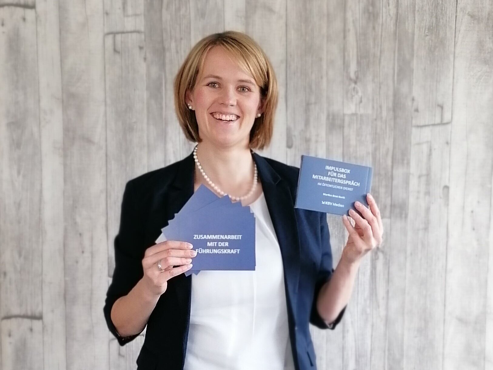 Eine Person hält Karten mit Text in beiden Händen.