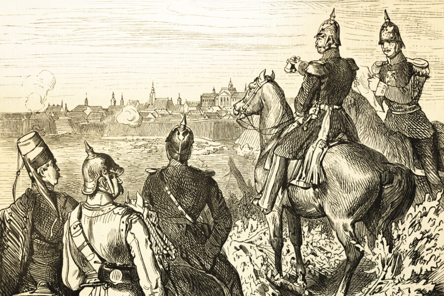 Fünf uniformierte Soldaten, vier auf Pferden, blicken auf eine befestigte Stadt.