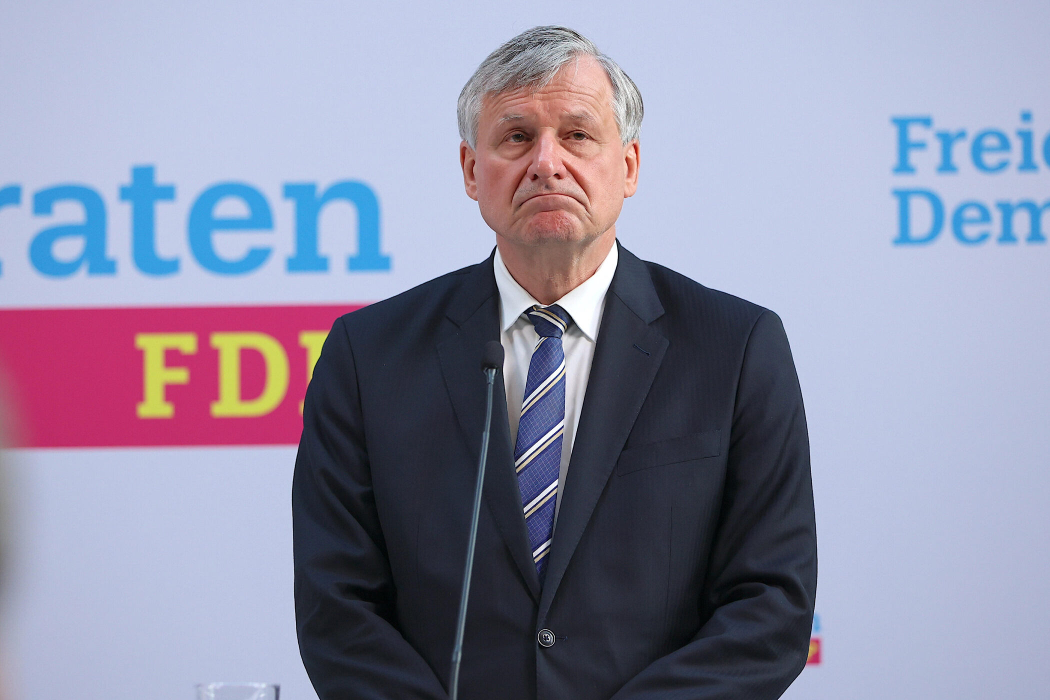 Ein Mann im Anzug vor einer Wand mit dem Text „FDP“ und „Freie Dem“.