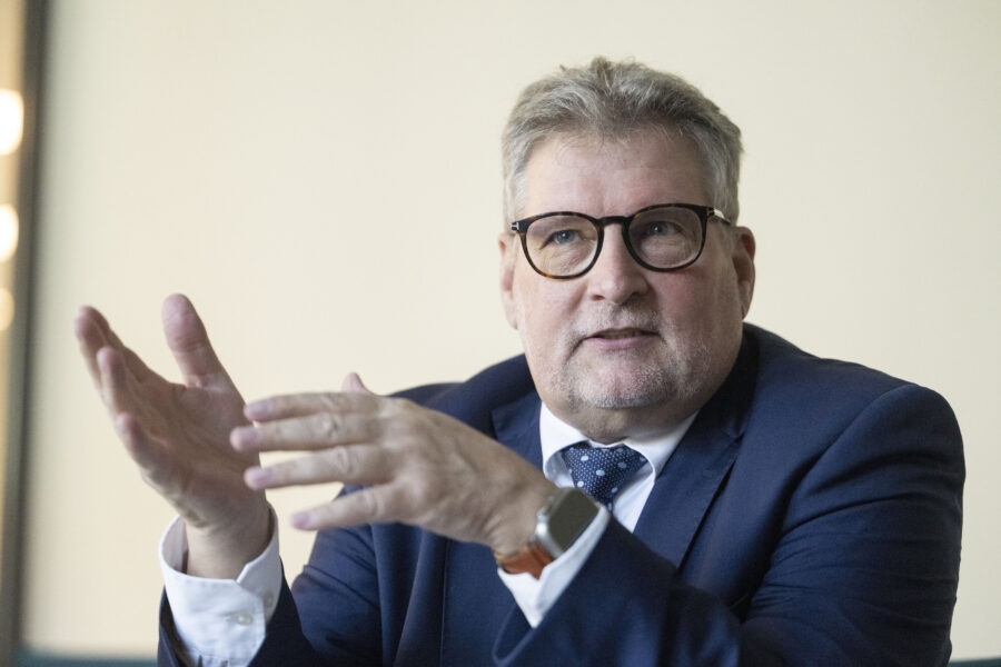 Ein Mann in einem Anzug gestikuliert mit den Händen.