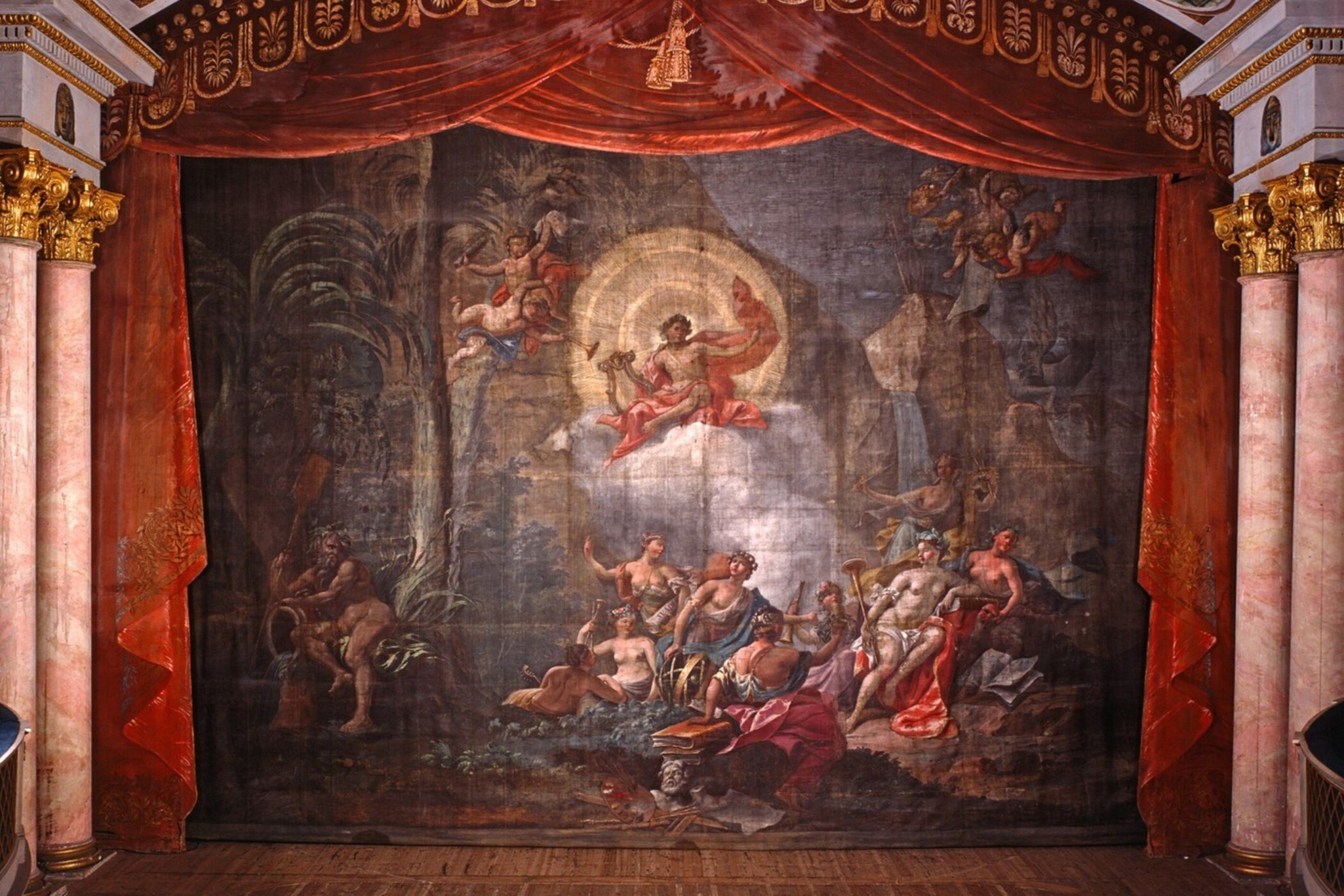 Theaterkulisse mit mythologischer Szene, Götter und Nymphen, umrahmt von rotem Vorhang.