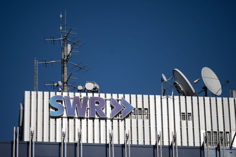 Gebäude mit Schriftzug "SWR", Antennen und Satellitenschüsseln auf dem Dach.