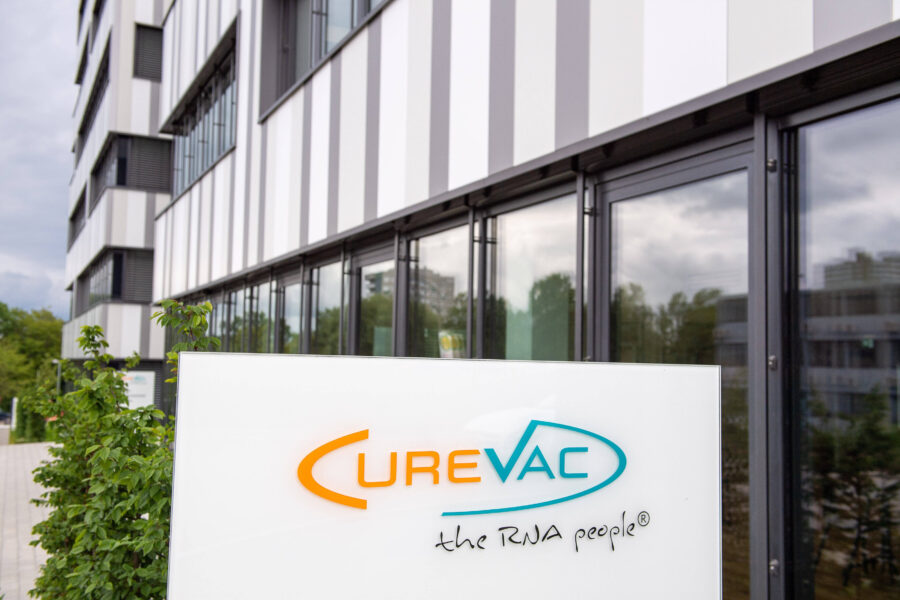 Firmenschild „CureVac the RNA people“ vor einem Bürogebäude.