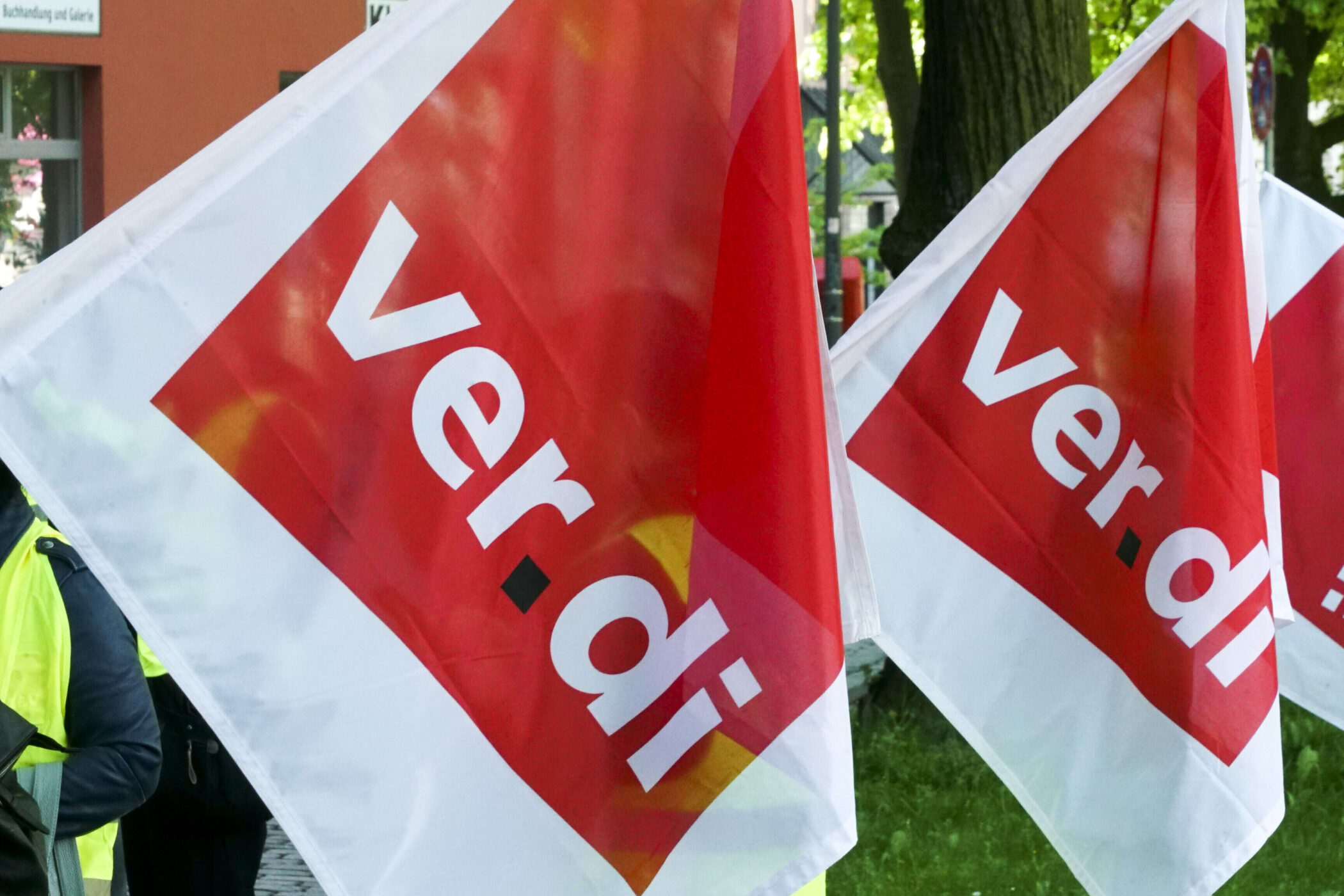Rote Fahnen mit "ver.di"-Aufschrift im Freien.