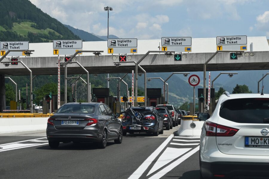 Autos an einer Mautstation mit Schildern "biglietto Ticket" und Fahrradsymbol.