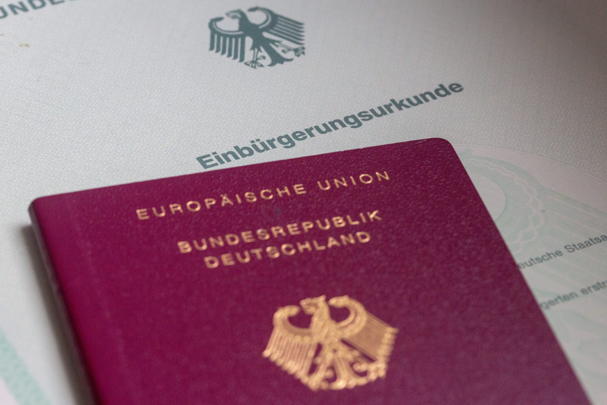 Roter deutscher Reisepass auf Einbürgerungsurkunde.
