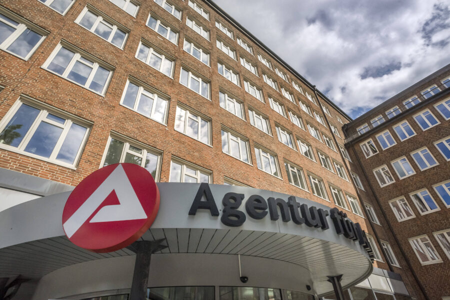 Backsteingebäude, Agentur-Logo und teilweise sichtbarer Schriftzug "Agentur fü".