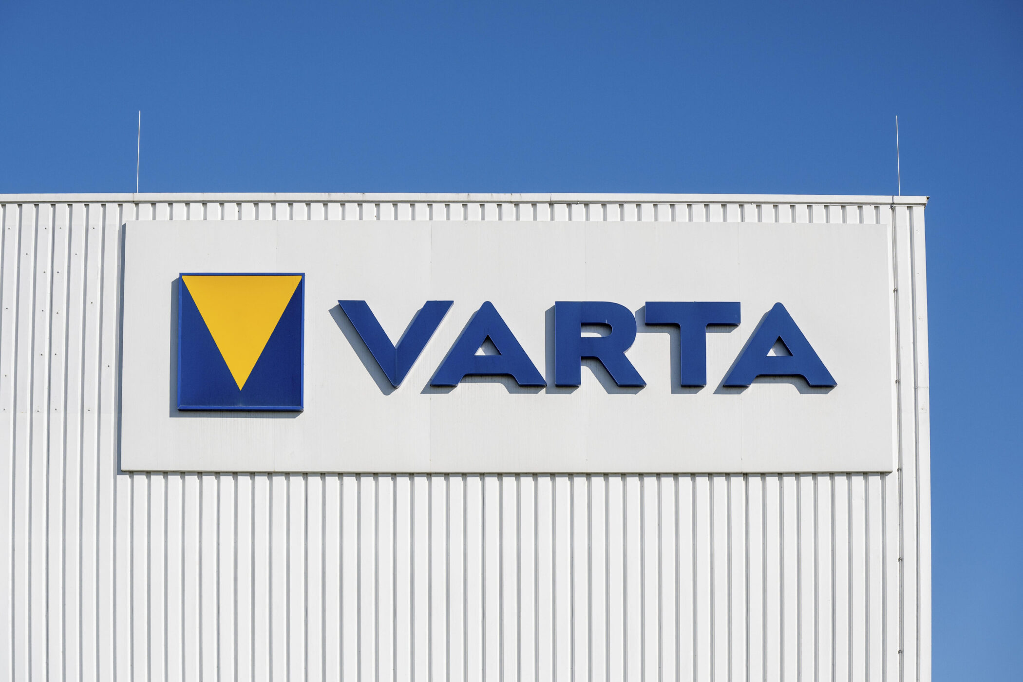 Weiße Fassade mit dem blauen Schriftzug "VARTA" und gelb-blauem Logo.