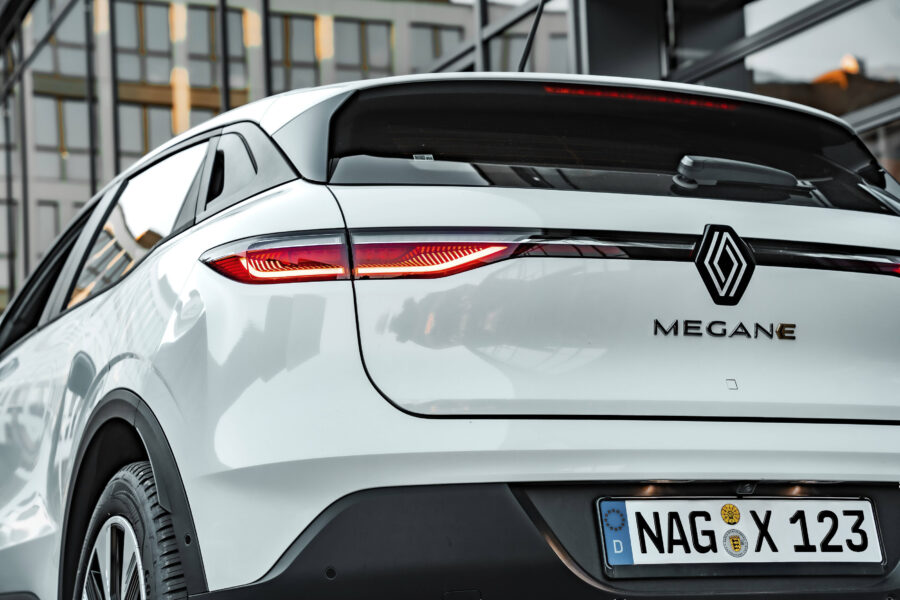 Weißes Auto von hinten, Markenlogo, „MEGANE“, Nummernschild „NAG X 123“.