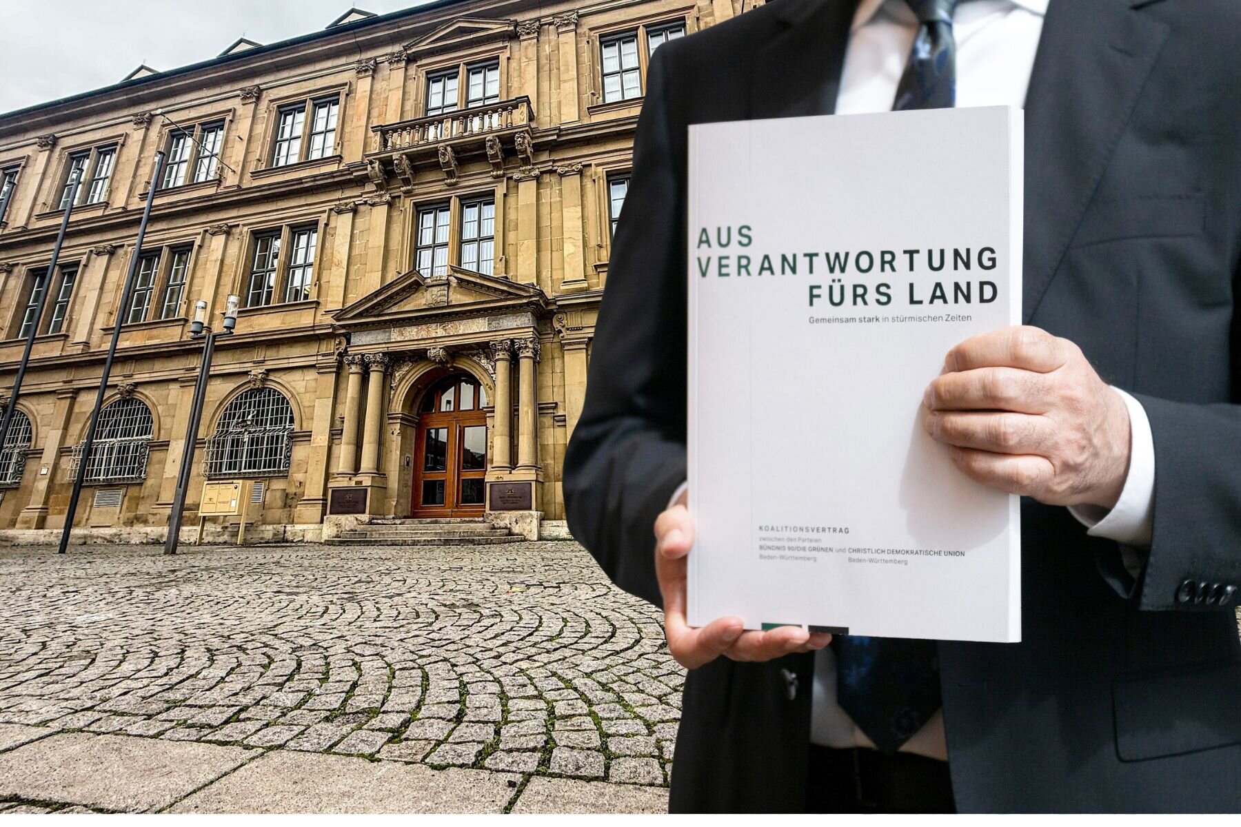Person hält einen Koalitionsvertrag vor einem historischen Gebäude.