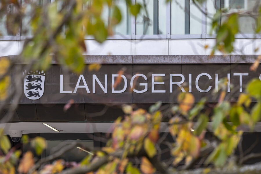 Schriftzug "LANDGERICHT" mit Wappen, verdeckt von bunten Blättern.