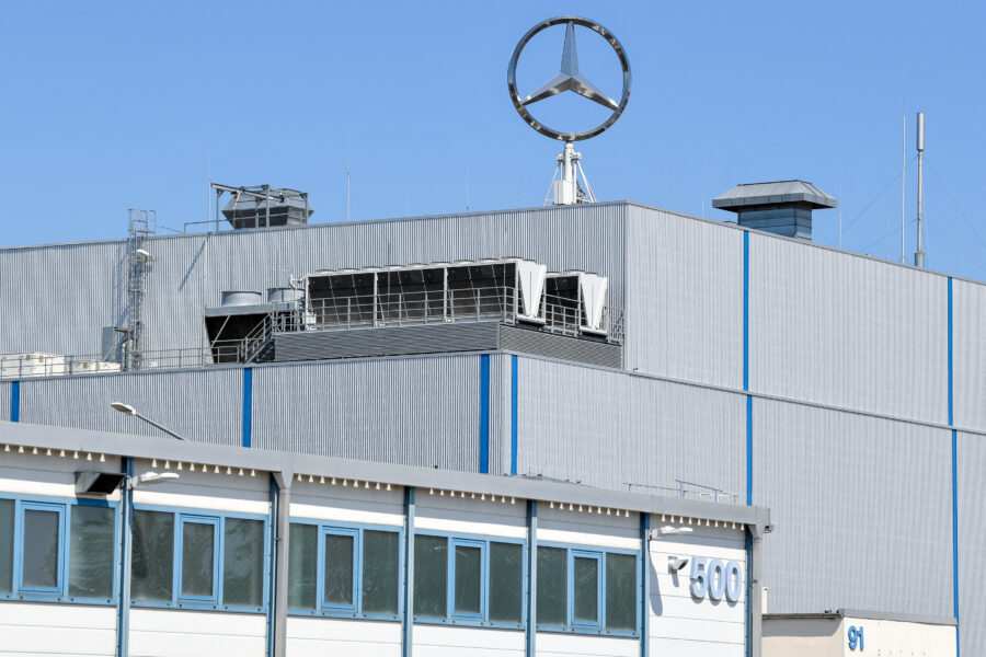 Graues Gebäude mit großem Mercedes-Logo oben, blaue Fenster, Nummer 500 sichtbar.