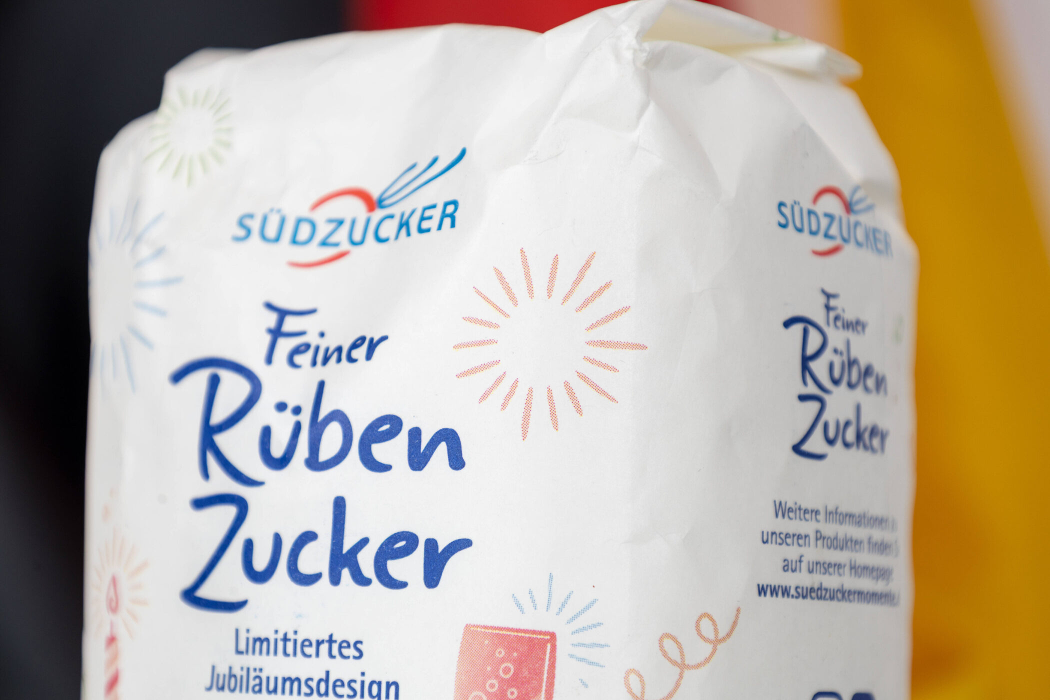 Packung mit der Aufschrift "Südzucker Feiner Rübenzucker", buntes Jubiläumsdesign.