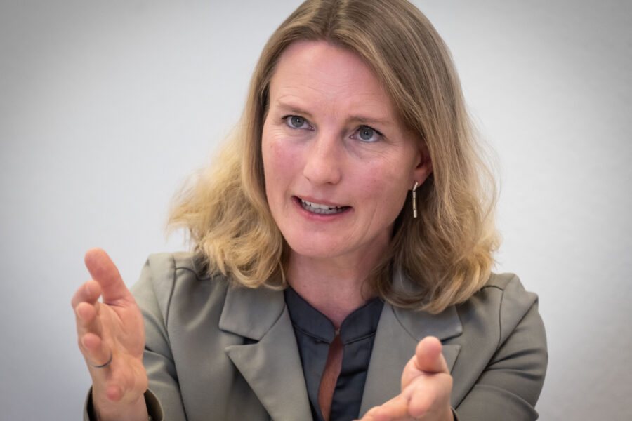 Eine Frau gestikuliert mit den Händen im Gespräch.