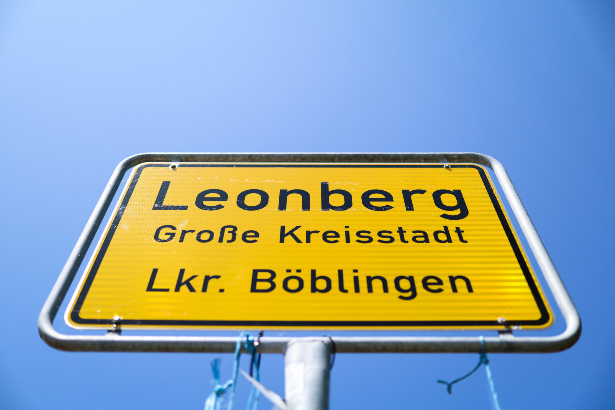 Gelbes Ortsschild mit der Aufschrift: Leonberg, Große Kreisstadt, Lkr. Böblingen.