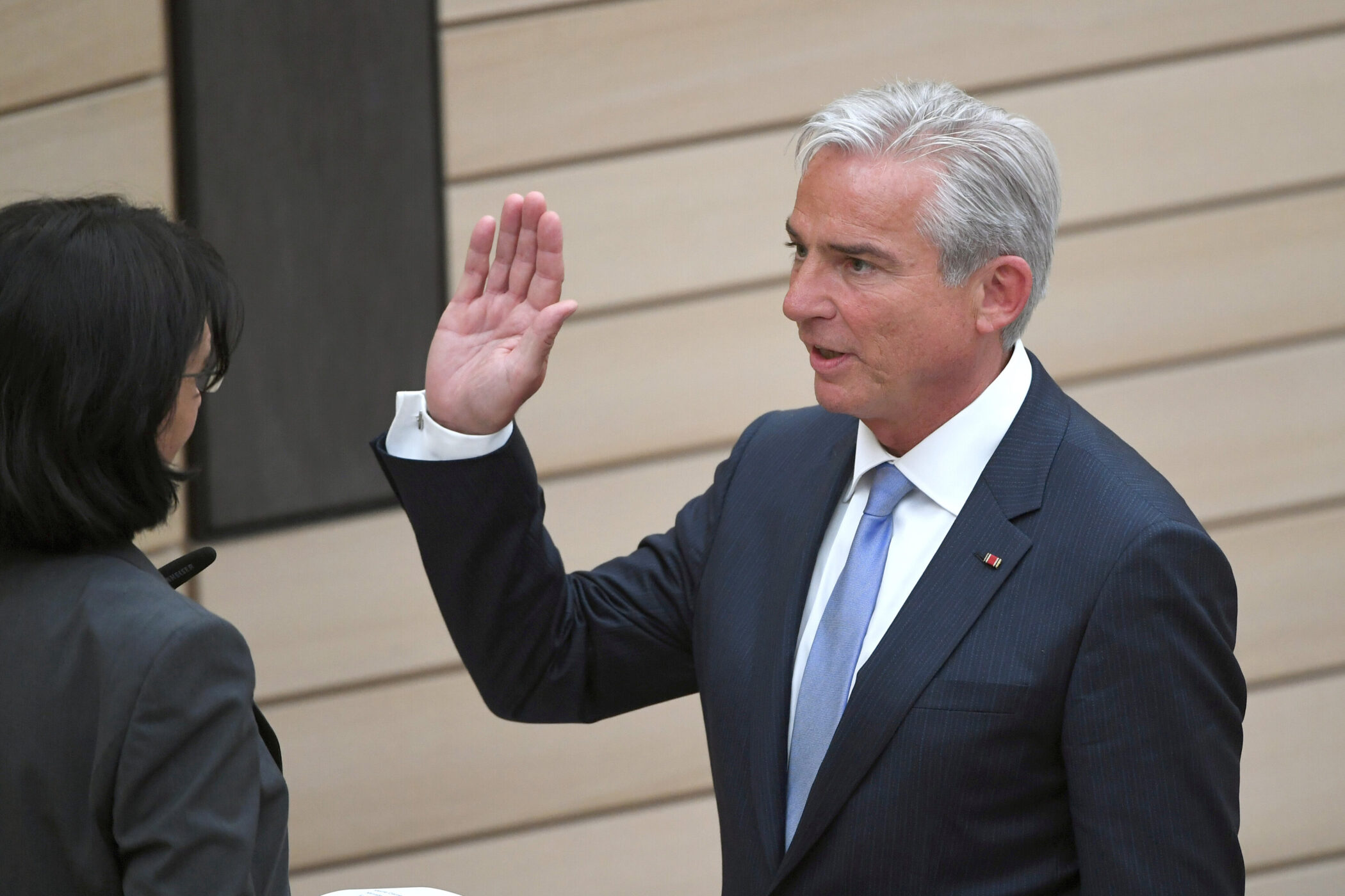 Eine Person hebt ihre Hand, spricht mit einer anderen Person.