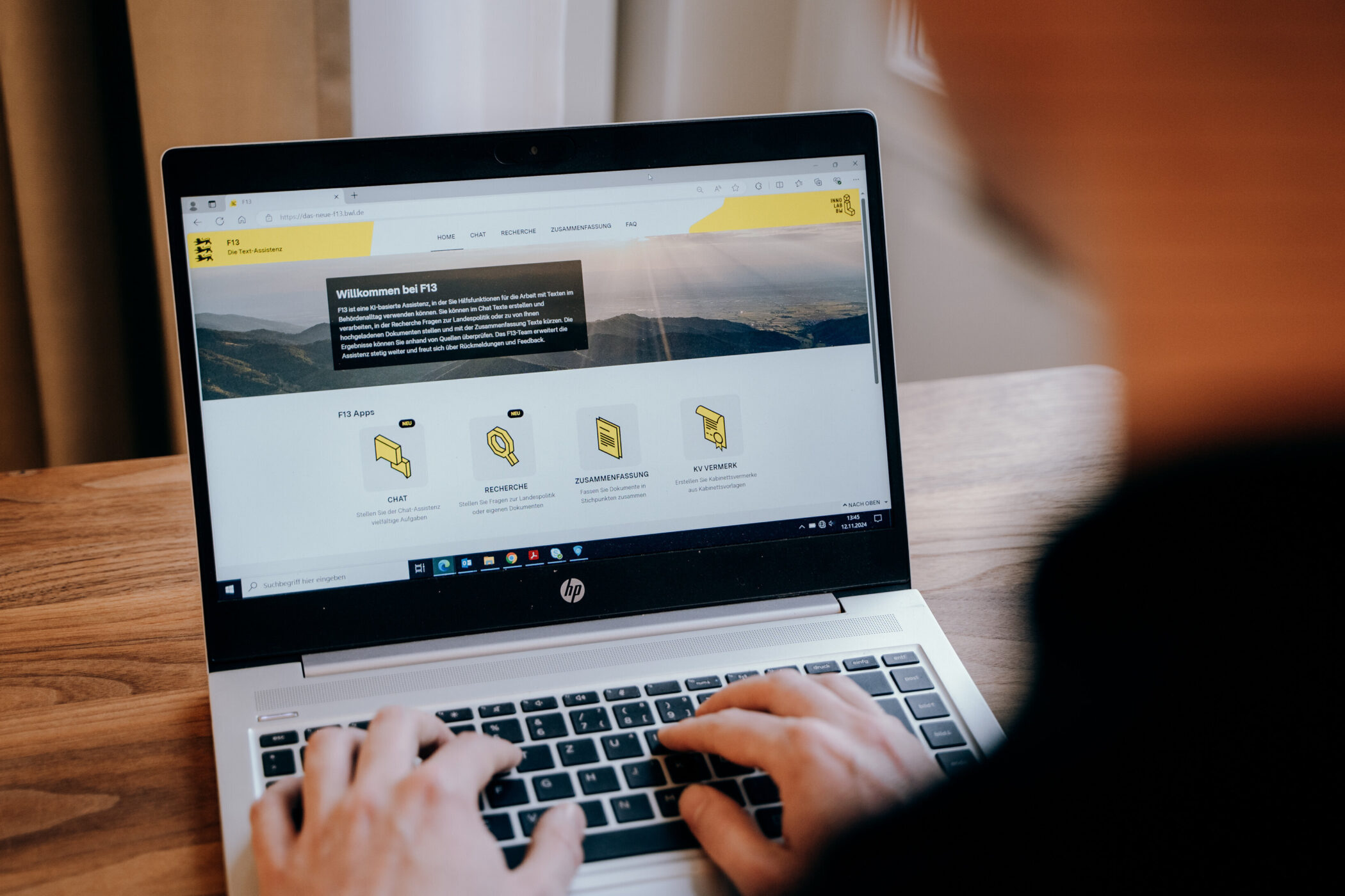 Person tippt auf Laptop mit geöffneter Webseite.