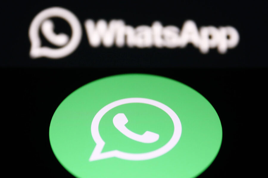 Grünes WhatsApp-Logo mit weißem Telefonhörer auf schwarzem Hintergrund.