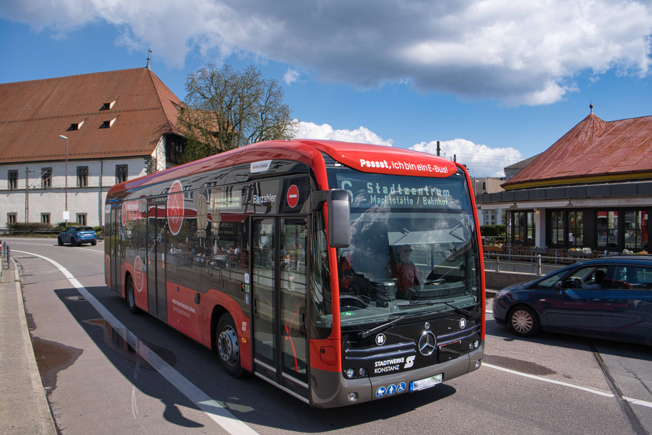 Roter Bus mit Schrift „Stadtzentrum Markstätte/Bahnhof“ fährt auf Straße.