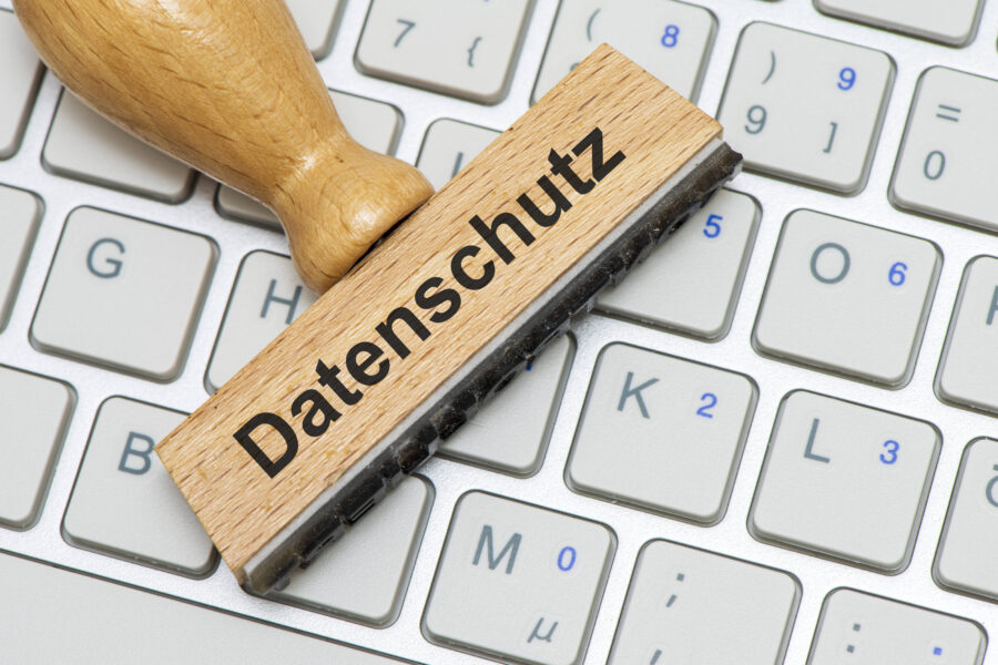 Holzstempel mit "Datenschutz" auf Computertastatur.
