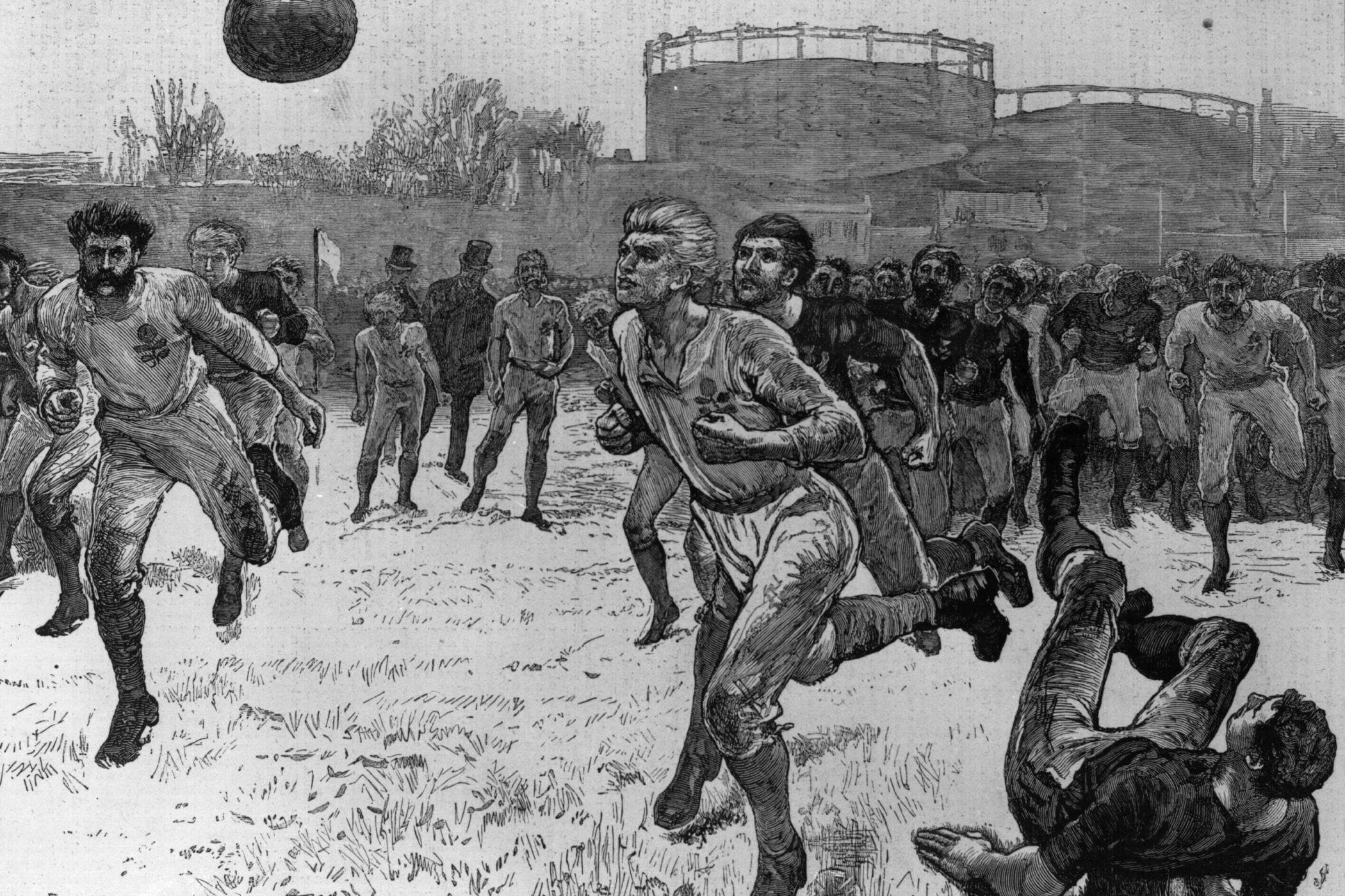 Mehrere Männer rennen im Freien einem großen Ball hinterher.