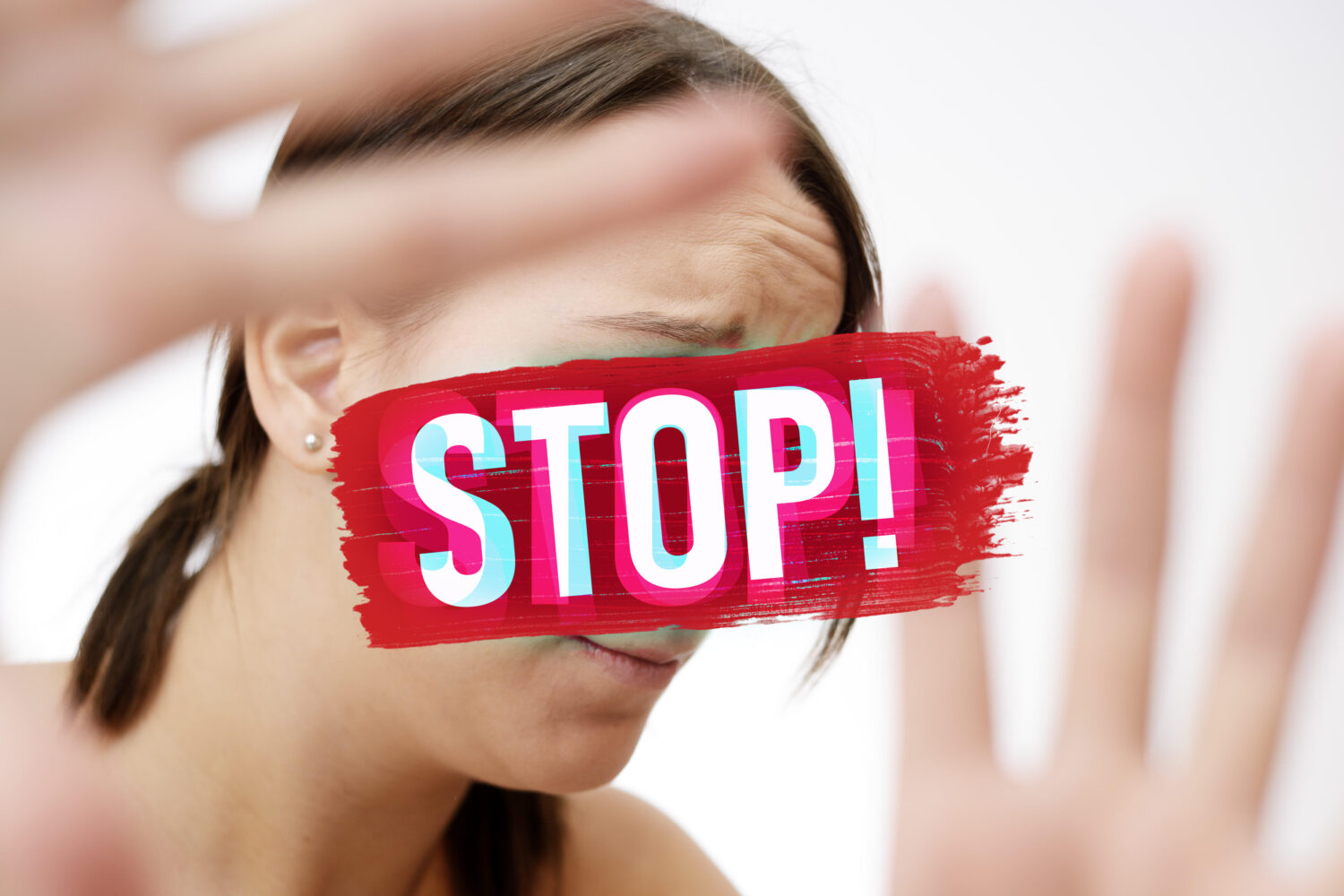 Frau hebt Hände, roter Pinselstrich mit Text "STOP!" über ihrem Gesicht.
