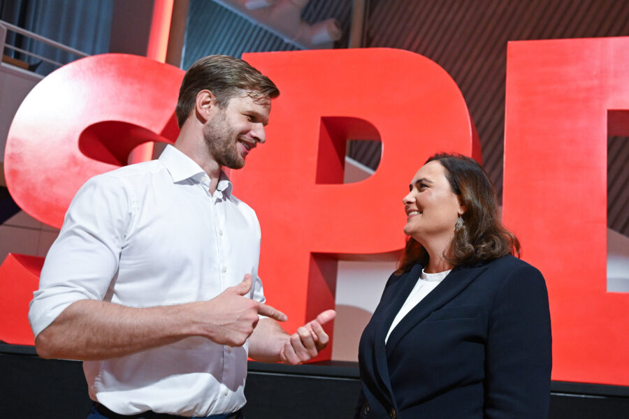 Zwei Personen im Gespräch vor großen roten Buchstaben "SPD".