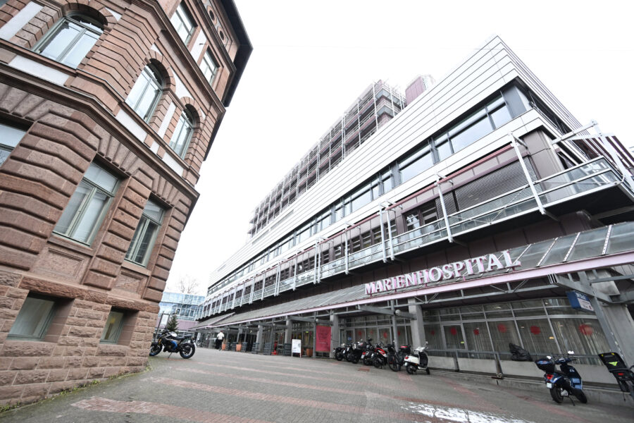 Zwei mehrstöckige Gebäude, Motorräder geparkt, Schriftzug "MARIENHOSPITAL".