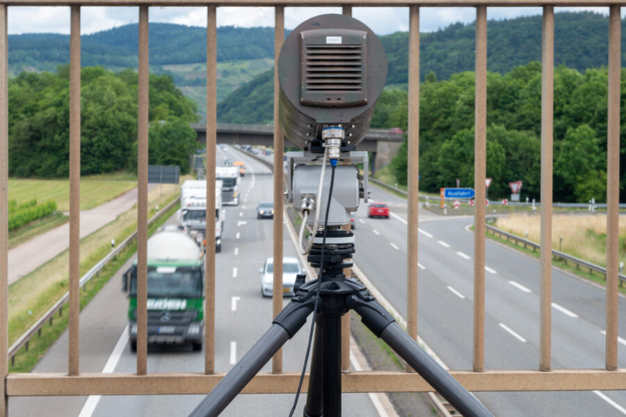 Radargerät auf Brücke über Autobahn, mehrere Fahrzeuge unterwegs.