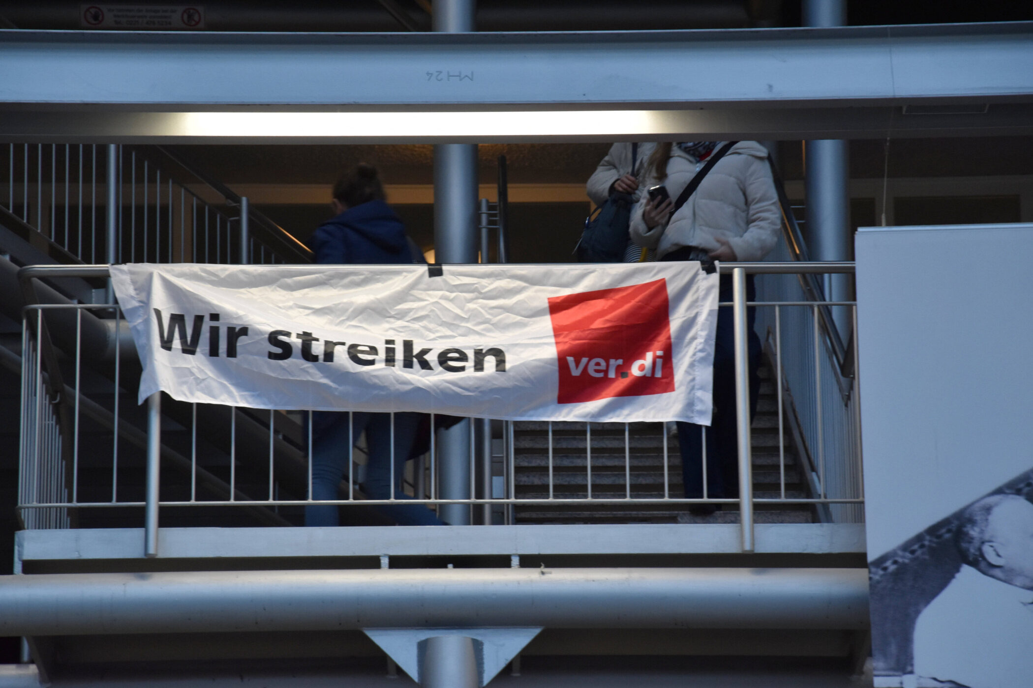 Transparent mit der Aufschrift "Wir streiken ver.di" an einem Geländer.
