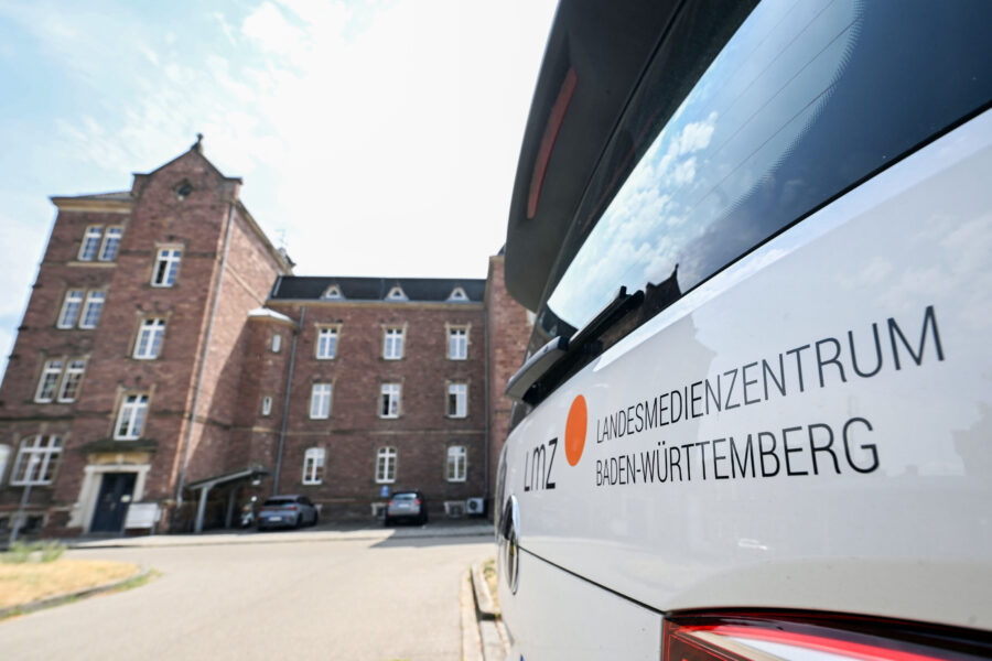 Auto mit Aufschrift "Landesmedienzentrum Baden-Württemberg", altes Backsteingebäude.