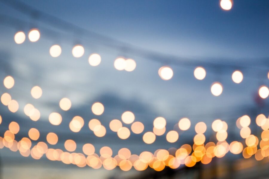 Lichterketten vor bewölktem Himmel, unscharf.