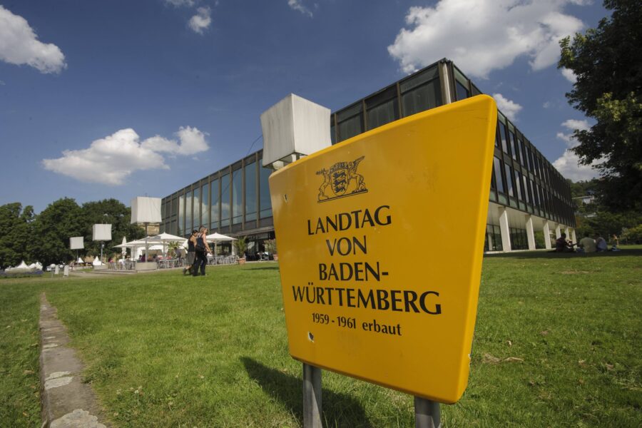 Gelbes Schild mit „Landtag von Baden-Württemberg, 1959-1961 erbaut“.