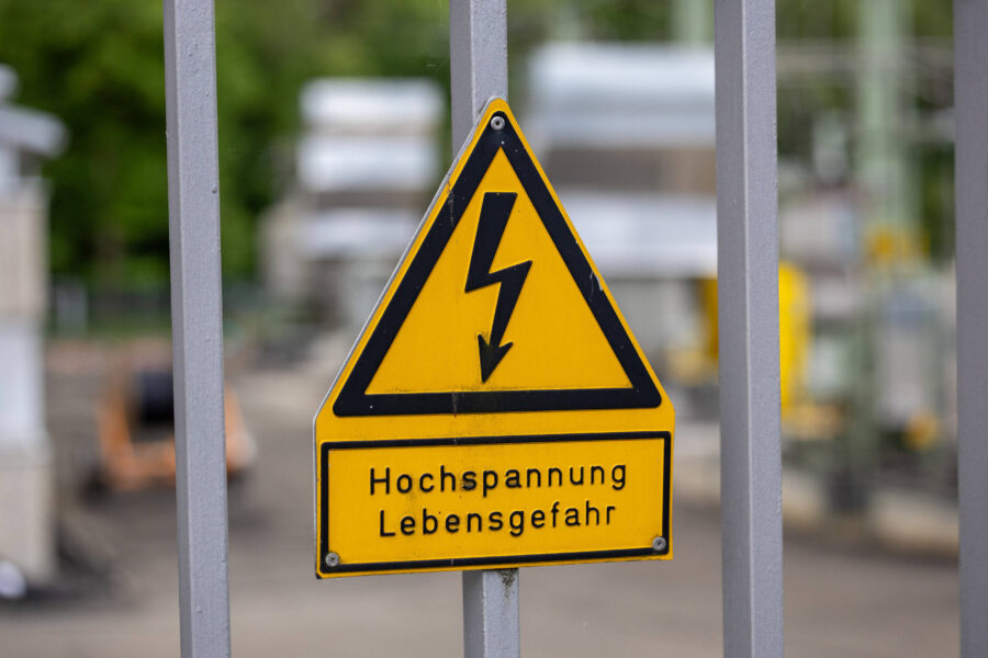 Dreieckiges Warnschild mit Blitzsymbol, Text: "Hochspannung Lebensgefahr".