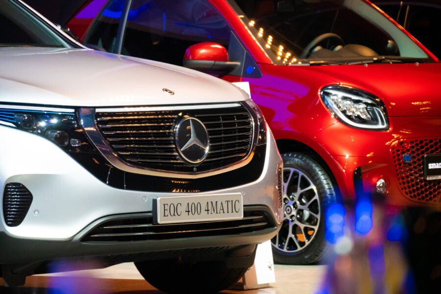 Zwei Autos: silberner Mercedes links, roter Smart rechts, Schriftzug "EQC 400 4MATIC".