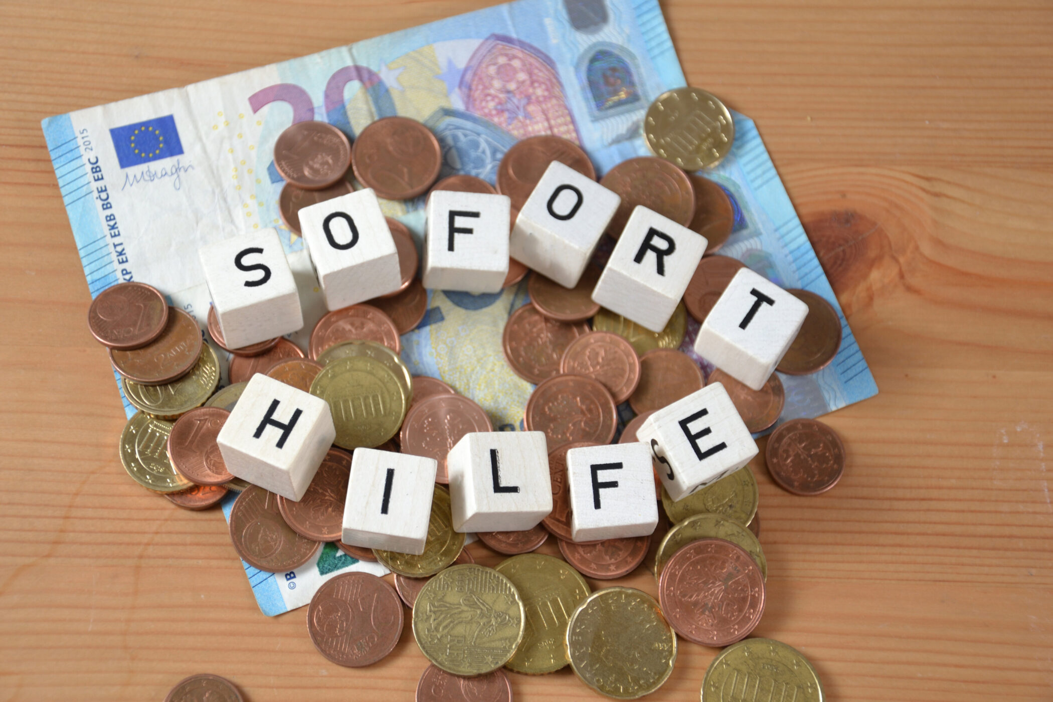Würfel "SOFORT HILFE" auf Euro-Geldscheinen und Münzen.