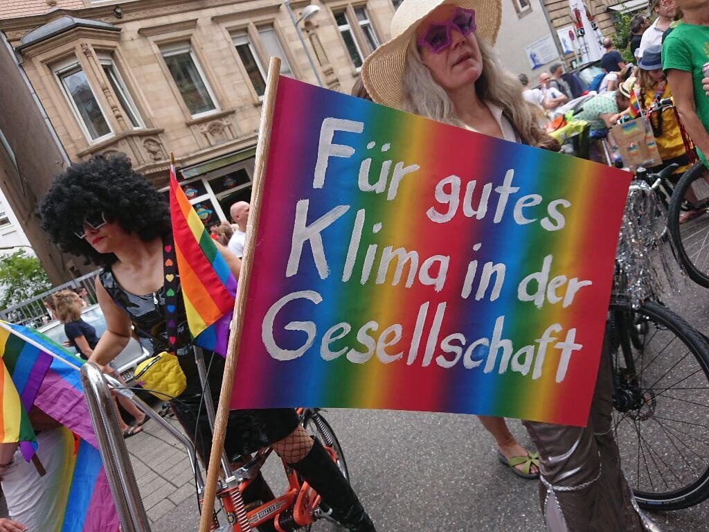 Zwei Personen in Kostümen halten ein Schild: "Für gutes Klima in der Gesellschaft".