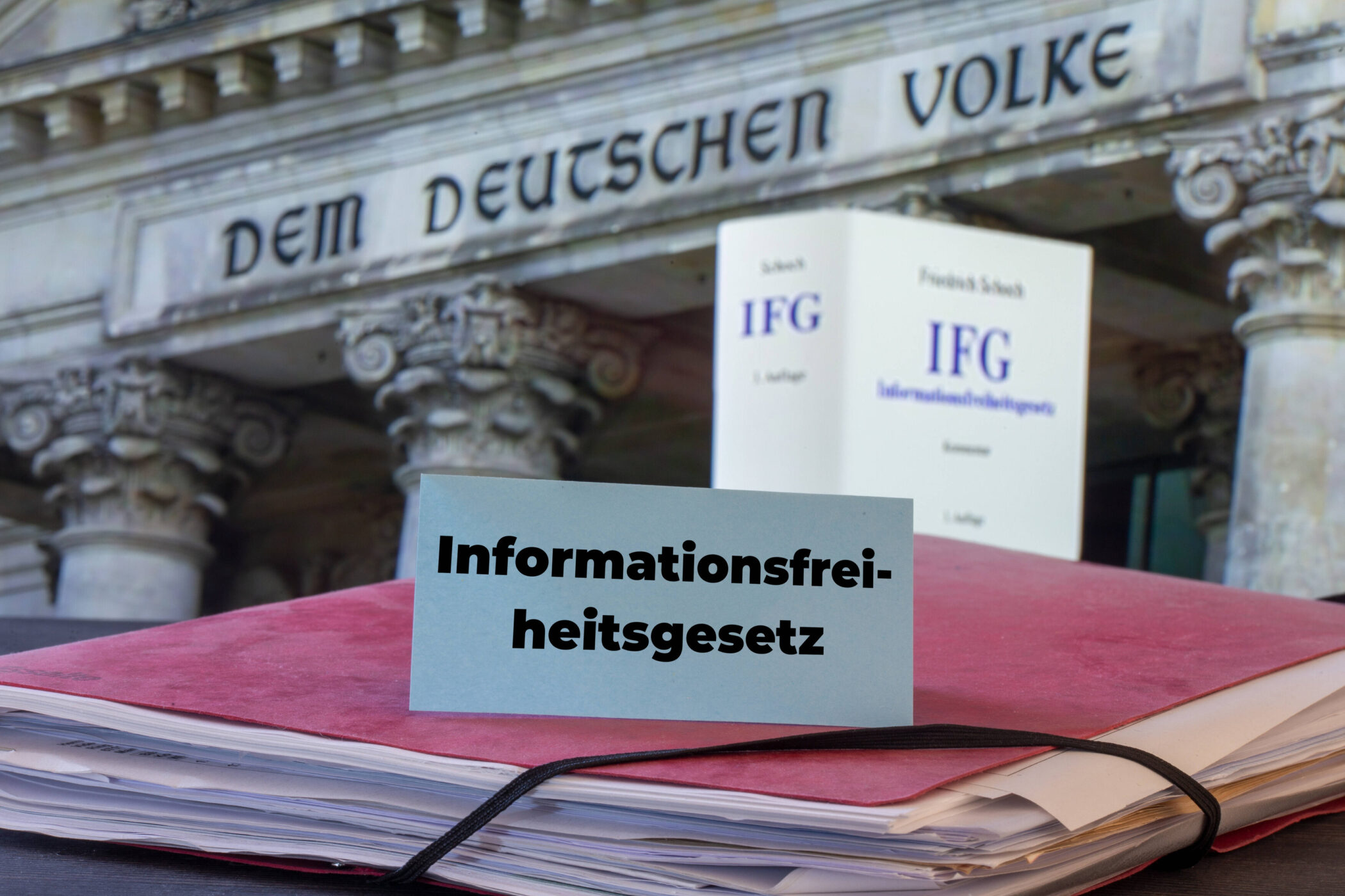 Text "Informationsfreiheitsgesetz" vor Akte, Schrift "DEM DEUTSCHEN VOLKE" sichtbar.