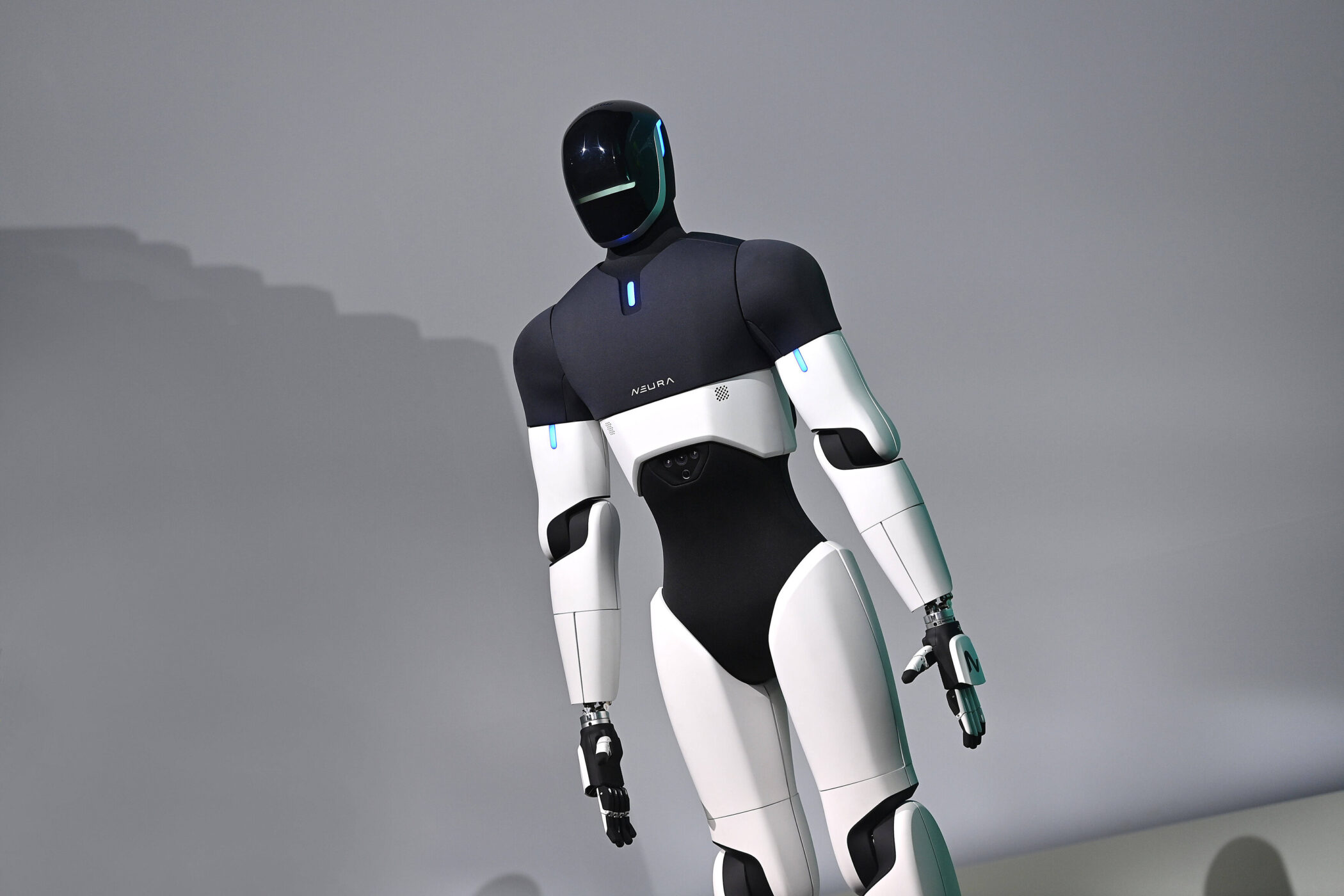 Humanoider Roboter mit schwarzem und weißem Körperdesign vor grauem Hintergrund.