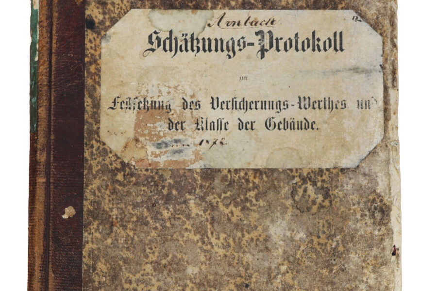 Altes Buch mit Aufschrift "Schätzungs-Protokoll" auf abgenutztem Einband.