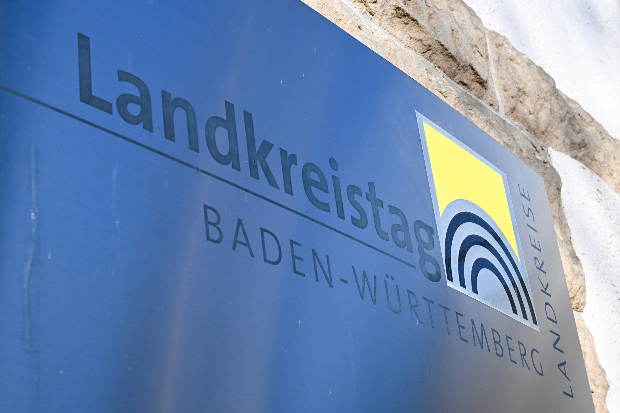 Blaues Schild mit Aufschrift "Landkreistag Baden-Württemberg" und einem gelben Logo.