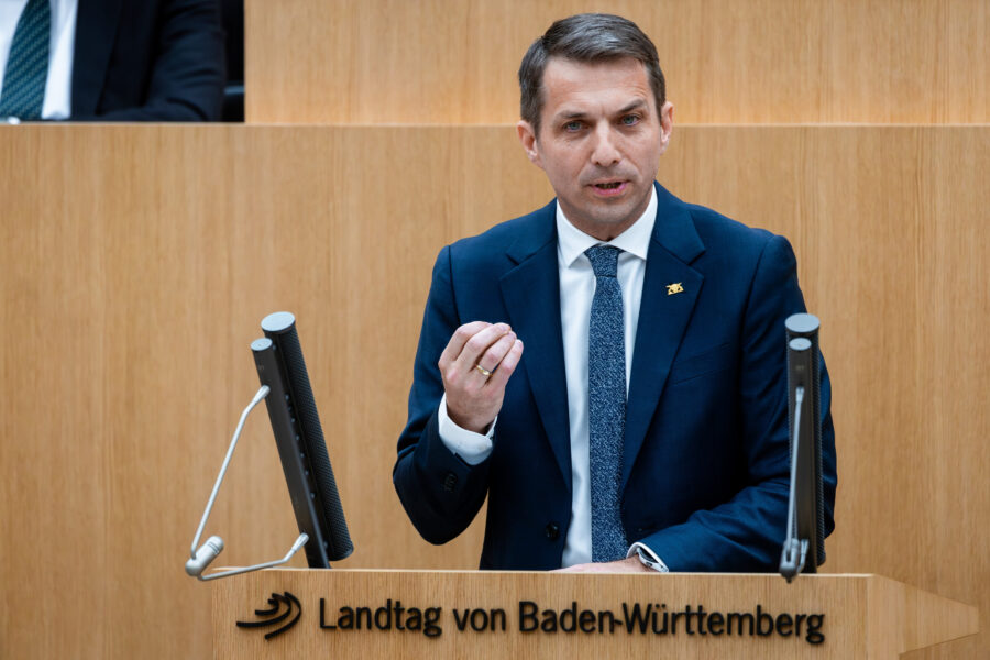 Mann im Anzug spricht am Rednerpult des Landtags von Baden-Württemberg.