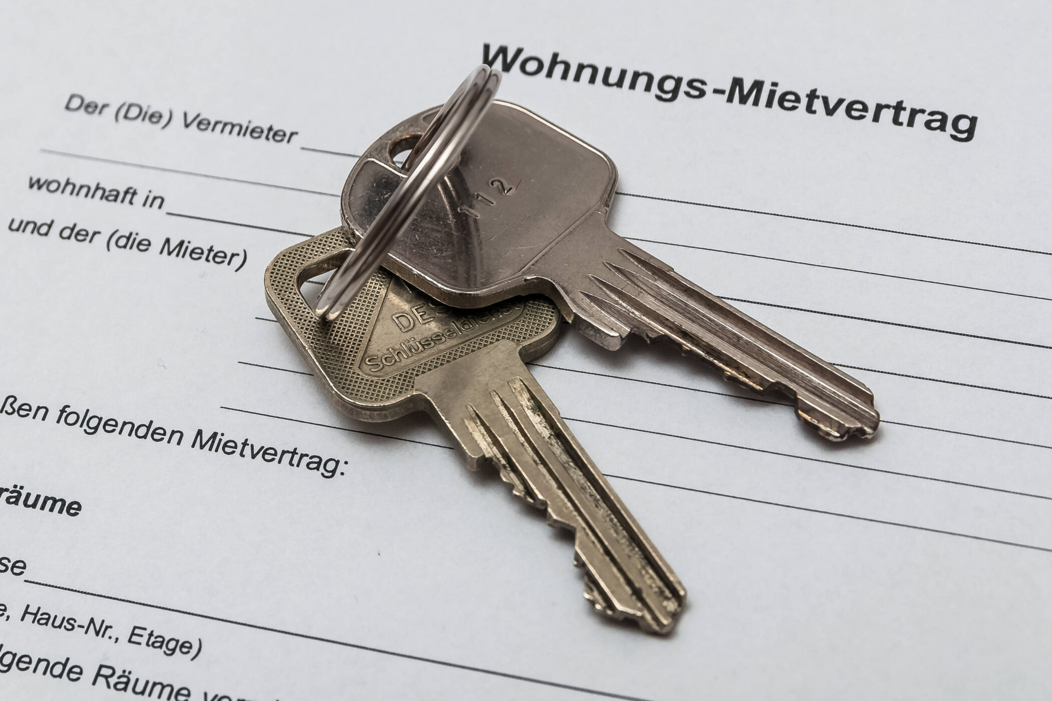 Zwei Schlüssel auf einem Wohnungs-Mietvertrag.
