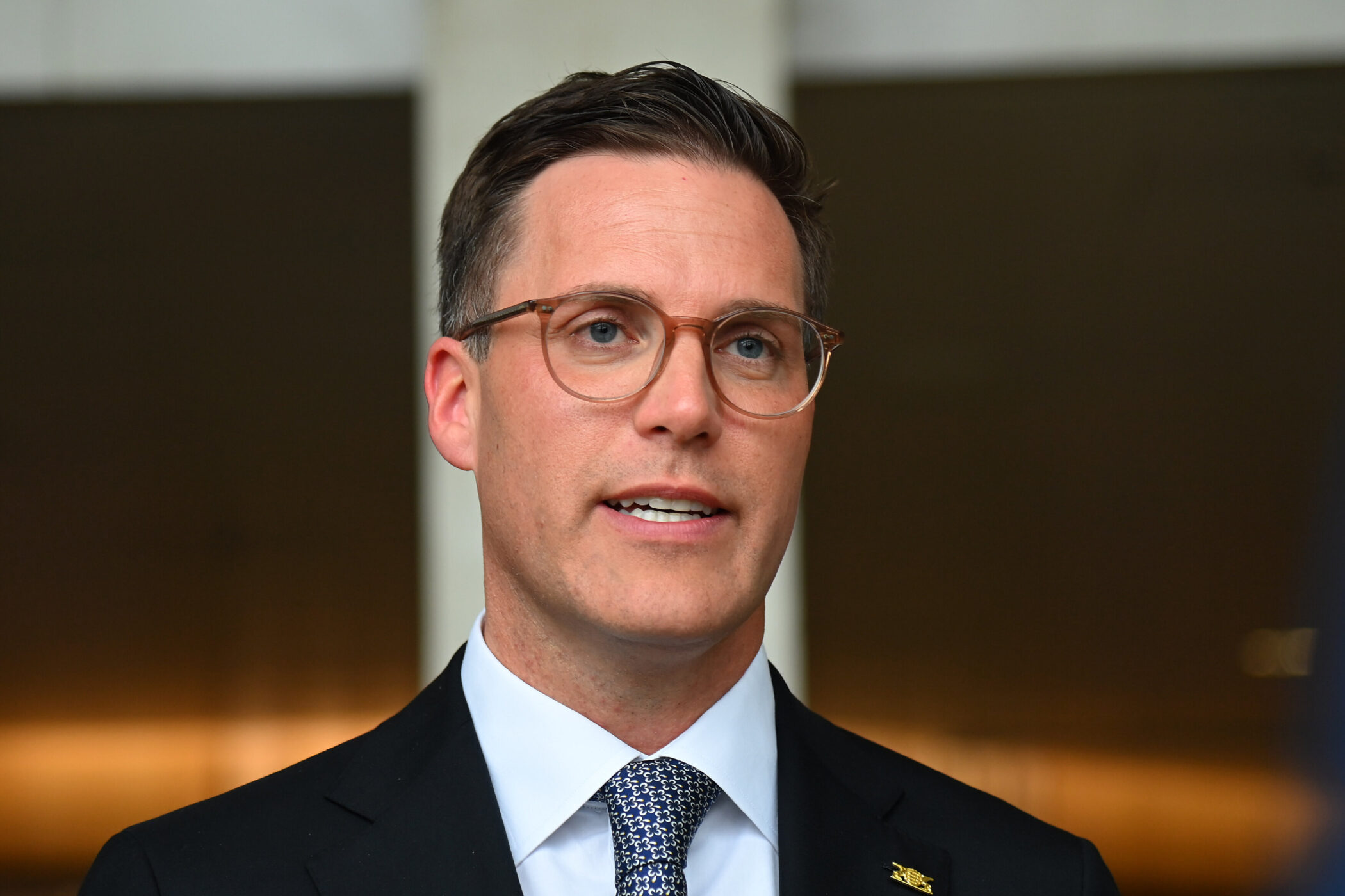 Ein Mann mit Brille im Anzug. Hintergrund unscharf.